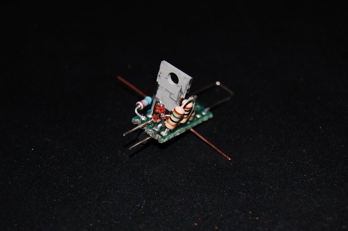 Dies ist die freiluftverdrahtete Schaltung auf der Lochrasterplatine. Sie besteht aus einen Gleichrichter mit 4 1N4148-dioden und danach 7,5-Ohm (10+15 parallel)-Vorwiderstand, der ein surren des elektronischen Halogentrafos verhindert. Dann kommt der Sieb-Elko, der ein 100-Hz-Flimmern vermeidet (der Trafo folgt den Nulldurchgängen, als wäre es ein konventioneller). Danach ist die übliche 2-Transistor-KSQ mit einem MOSFET im TO220-Gehäuse und einem BC547, der dem MOSFET den Hahn zudreht, sobald am Shunt ca. 0,63V erreicht sind. Der Shunt hat 5,6 Ohm, somit ergeben sich etwas weniger als 120 mA.<br />Um bei Messungen und dadurch entstehenden Überbrückungen die LEDs zu schützen, ist dem Elko ein 4,7 kOhm-Widerstand parallel geschaltet, der ihn auf 0 entlädt.