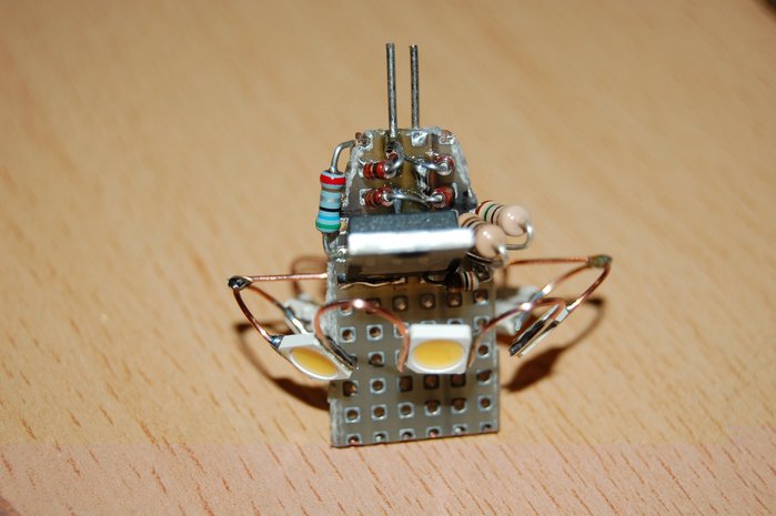 Und hier das nächste Exemplar. Oben klar zu erkennen sind die vier 1N4148-Dioden, die zu einem Brückengleichrichter verschaltet sind, links der 5,6-Ohm-Shunt für die Strommessung, rechts 10+15 Ohm paralle als "Abfederung" der Sinusspitzen des Netzteils, um Netzteil und Elko zu schonen (der Elko ist hier noch nicht eingelötet). Der Große Transistor ist ein N-Kanal-MOSFET, recht unten davon ist ein 1k-Ohm-Widerstand, der das Gate des MOSFET mit positiver Spannung versorgt. Auf der Platinenunterseite ist ein BC547, der bei ca. 0,63 Volt Spannungsabfall am 5,6-Ohm-Shunt dem MOSFET die Gate-Spannung verringert, so dass sich knapp unter 120 mA bei dieser KSQ einstellen.